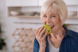 older woman eating apple